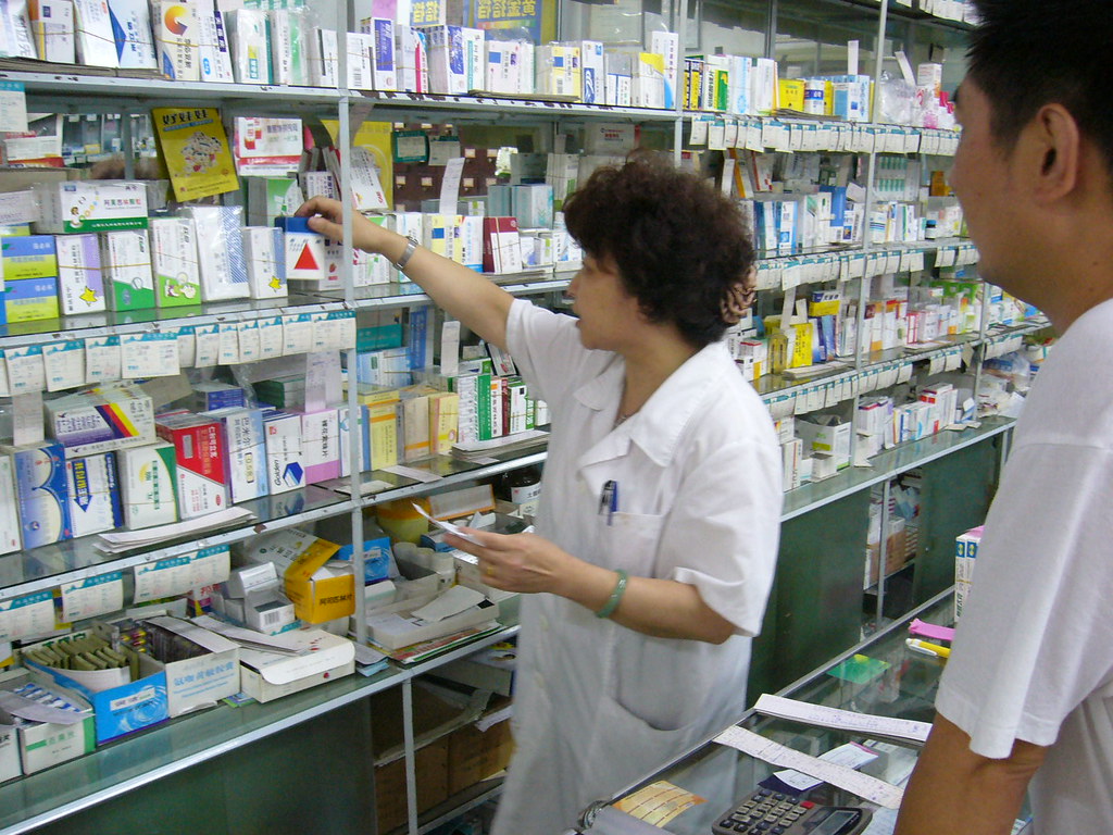 Chinese pharmacy technician grabbing medicine for customer… | Flickr